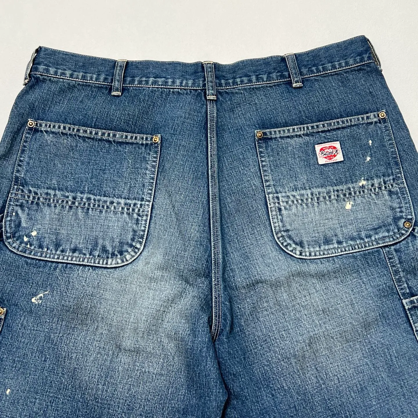 SAINT Mxxxxxx DOUBLE KNEE SHORTS/BLU Knee patches splashed with ink and water-splashed denim shorts. Denim blue S-XL. Custom-woven and dyed denim fabric with clear texture. Heavy-wash water-fading treatment to create local mottled fading/hole effects. Artificial distressing to simulate natural wearing marks. VINTAGE sense. Original consistent damage treatment. Hand-splashed ink and paint. Original consistent wash mark/pocket mark. Double knee patch. Rivet reinforcement. Improve functionality while enhancing design